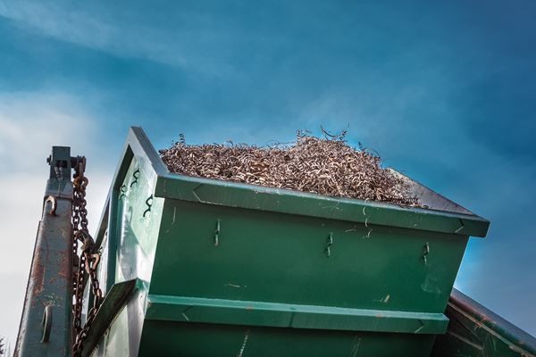 Grüner Schrottcontainer auf LKW mit Kranseil